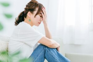 顔に手を当てて後悔する女性の写真
